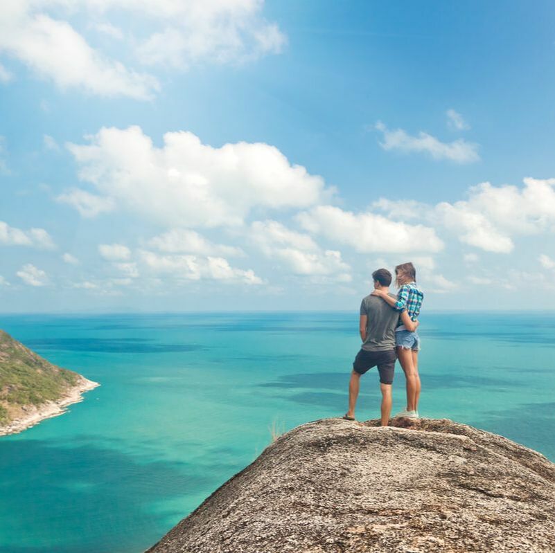 couple at the top of a mountain overlooking sea
